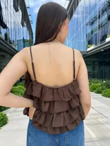 Blusa color amarillo manteca con breteles finos, escote en V con detalle de encaje y volados en capas.