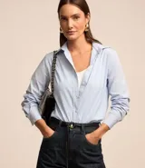 Camisa de mujer de tricolina, con cuello solapa, abotonado delantero y mangas largas. Presenta un estampado de rayas verticales finas en azul marino y blanco.