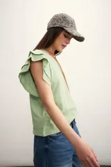 Remera color amarillo pastel con cuello redondo y mangas cortas con volados.