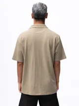 Camisa de manga corta color azul marino, confeccionada en tejido piqué de algodón. Presenta cuello cubano y cierre frontal de botones. Incluye un bolsillo de parche en el pecho izquierdo.