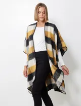 Ruana de tejido soft, color rosa pálido, celeste, gris y beige, con diseño a cuadros. Presenta terminación en zig zag con lana en los bordes y sisa amplia.