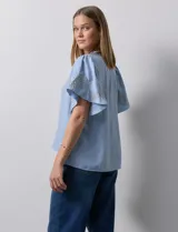 Blusa color beige de crepe, marca Batía, con cuello a la base y escote en V. Manga corta amplia con bordados.