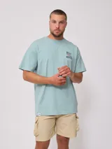 Remera celeste de hombre, corte holgado, con estampado en el frente y la espalda con el texto "Rusty Mantra".