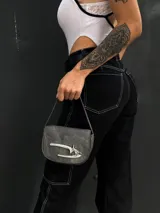 Mini bag gris con correa fina y cierre con forma de gancho plateado.