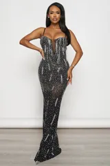 Vestido largo de fiesta negro, corte sirena, con escote en V profundo y breteles finos regulables. Confeccionado en tul elastizado con forro interior y aplique de tul transparente en el escote. Decorado con strass plateados y tornasolados.