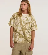 Remera de algodón color crudo con estampado de ramas y hojas en tonos marrones. Corte boxy, cuello redondo y mangas cortas.