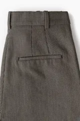 Pantalón ancho de vestir con estampado a cuadros en tonos marrones y negros. Modelo de tiro alto con elástico oculto en la cintura y cierre. Bolsillos al bies, bolsillos decorativos insertados atrás y piernas rectas amplias con pliegues adelante.