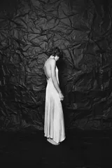 Vestido midi plateado confeccionado en hilo metalizado, con escote recto, tirantes finos y forro interior combinado.