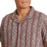 Camisa de manga corta con cuello cubano y estampado geométrico en tonos burdeos, gris y ocre.