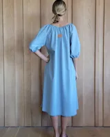 Vestido midi color coral, de corte suelto, con escote con lazo y mangas abullonadas 3/4.