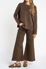 Sweater color marrón claro de tejido de punto, con cuello redondo y mangas largas.