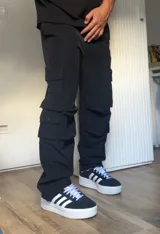 Pantalón cargo negro de corte recto con múltiples bolsillos con solapa y botón a presión.