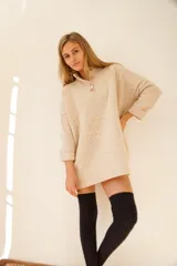 Sweater color ocre de lana de cordero con cuello alto abotonado y calce oversize.