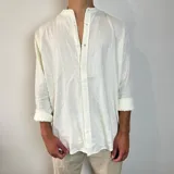 Camisa de lino color blanco, de manga larga con puños abotonados y cuello mao. Corte oversize.