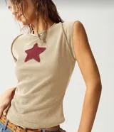 Remera color beige de tejido acanalado, corte ajustado, cuello redondo y mangas cortas. Tiene un parche de estrella color borgoña en el pecho.