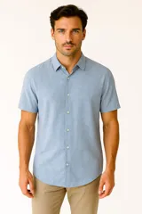 Camisa celeste con estampado de flores blancas, de manga corta y cuello clásico. Cierre frontal con botones.