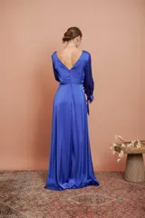 Vestido largo de satén color azul eléctrico, con escote en V cruzado, mangas 3/4 con lazos en los puños y tajo lateral alto.