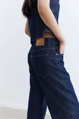 Jean de tiro alto con piernas anchas y rectas, de denim azul oscuro.