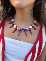 Collar corto con cuentas de nácar teñidas en colores y barritas de coral. Se cierra con cadena de acero quirúrgico y ganchito para regular el largo.