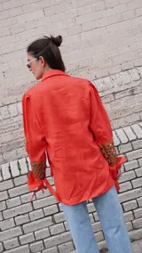 Camisa color naranja de lino con mangas abuchonadas y detalle calado en los puños.
