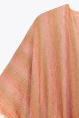 Vestido largo tipo kaftán confeccionado en lino a rayas verticales en tonos naranja y verde. Tiene cuello redondo con escote en V, mangas cortas amplias, acabado deshilachado y cinturón de cordón en el mismo tejido.