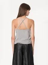 Top negro confeccionado en tela de punto con strass, con breteles finitos que se cruzan en la espalda y escote tipo halter.
