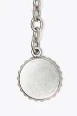 Charm para bolso con cuerda anudada en tonos borgoña, azul y beige, con abalorios metálicos plateados y mosquetón para colgar.