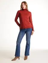 Polera tejida en hilado fino color verde oscuro, de manga larga con tajo en el puño y cuello alto.