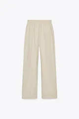 Pantalón negro de lino, de tiro alto con cintura elástica ajustable con cordones, bolsillos delanteros y pernera recta.