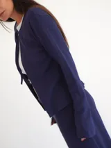 Saco color beige de tejido de punto con textura acanalada.