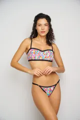 Top de bikini con escote corazón y estampado floral en tonos rosa, naranja, amarillo y blanco. Tiene breteles finos regulables y contorno inferior en color celeste.