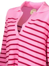Sweater de punto color crema con rayas horizontales negras, cuello polo con escote en V y mangas largas.