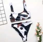 Conjunto de bikini con estampado animal en tonos marrón, negro y blanco. El top es de corte recto con tirantes anchos y la parte inferior es de corte clásico.