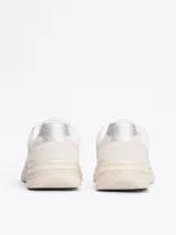 Zapatillas deportivas Tommy Hilfiger de corte bajo, color blanco con detalles en celeste y plateado. Presentan paneles de malla y superposiciones de gamuza, con el monograma TH en la lengüeta y el lateral.