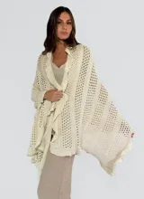 Pashmina calada color crudo con diseño de tejido abierto y flecos en los bordes.