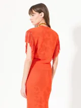 Top color naranja tejido con calados, sin mangas y con flecos en las sisas.