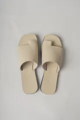 Sandalias planas de cuero color negro, con tira ancha sobre el empeine y diseño minimalista.