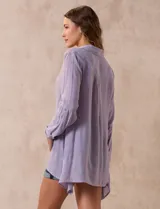 Camisa color beige claro, de corte recto y mangas 3/4 con botón para sujetar.