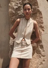 Minifalda beige de tiro bajo con cinturón y hebilla metálica, confeccionada en tejido denim de algodón.