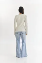 Sweater color beige con diseño tejido en relieve de cuadrados y rectángulos.