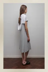 Vestido midi gris de viscosa, con corte evasé, mangas cortas y escote redondo.