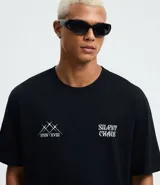 Remera relaxed de algodón color negro, con estampado frontal de diseño tribal y la frase "Silent Chaos" en blanco.