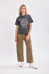 Pantalón jean cargo color verde militar, de corte recto y tiro alto, con bolsillos laterales y traseros.
