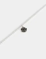 Collar corto de perlas sintéticas con dije de rosa metálica plateada y cierre de cinta de terciopelo negro.