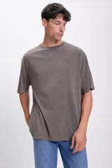 Remera gris oscuro de corte oversize, con cuello redondo y mangas cortas.
