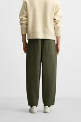 Pantalón de hombre color beige, corte carrot fit, con cintura elástica ajustable con cordón, bolsillos frontales y bolsillo trasero de plastrón.