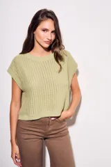 Chaleco de punto color beige con lurex, de corte recto y mangas cortas. Tejido calado con pequeños agujeros.