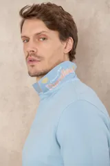 Remera tipo polo color beige, de manga corta y corte clásico. Tiene cuello con botones y está confeccionada en algodón.