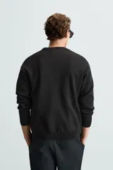 Jersey marrón de punto suave, corte regular, cuello redondo y manga larga con terminaciones en rib.