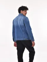 Campera de jean azul con cuello clásico, cierre frontal con botones metálicos, bolsillos con solapa abotonada en el pecho y bolsillos laterales.